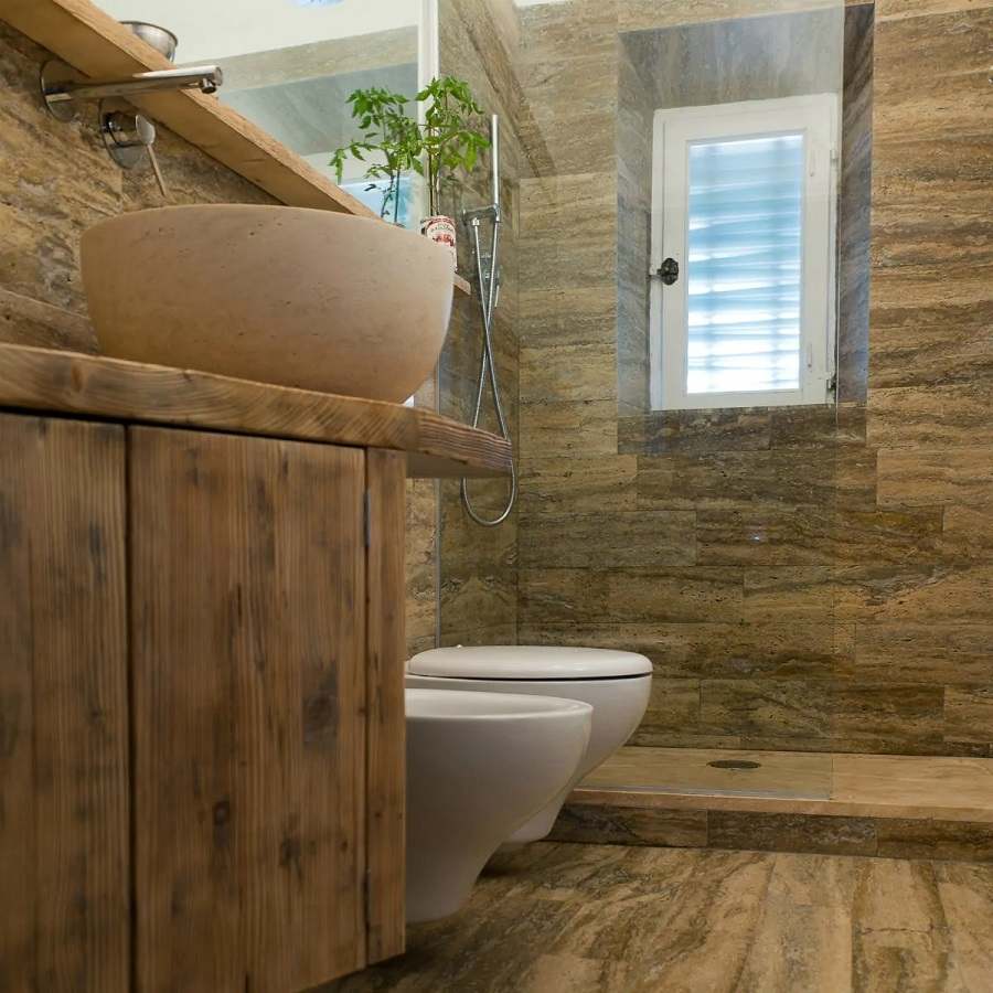 Salle de bain en travertin avec lavabo et meuble en bois
